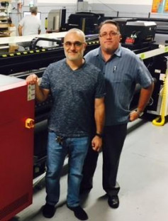 Bert Santana (left) and Cesar Casamayor, owners, i2K Digital Solutions, stand with their new Anapurna RTR3200i LED from Agfa Graphics.