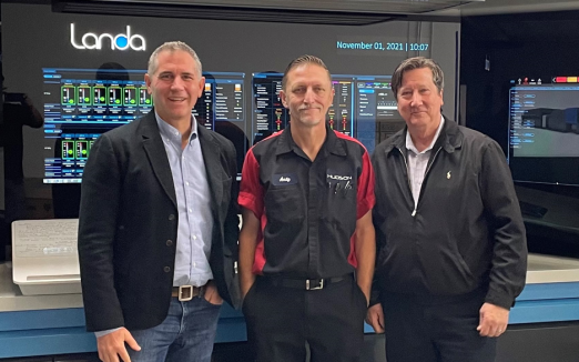 Paul Hudson, CEO; Andy Anderson, Head Pressman; and Steve Furlong, General Manager, stand in front of Hudson Printing&rsquo;s new Landa S10P digital printing press.