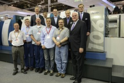 The Allied Printing Services team meets with KBA at its booth at drupa. (Top row, left to right) Ralf Sammeck, KBA president and CEO of Sheetfed Solutions; Edward Heffernan, KBA sales manager; John Sommers, president and CEO of Allied Printing Services; Mark Hischar, president and CEO of KBA North America; and KBA Group President and CEO Claus Bolza-Sch&uuml;nemann. (Bottom row, left to right) Kevin Howard, Allied pressroom manager; Mark Flinn, Allied finishing manager; Jim Morse, Allied digital solutions manager; Chris Gouveia, Allied senior VP of operations; Jon Kaufman, Allied senior VP of technical development; and Soren Larsen, KBA senior VP of sheetfed sales.