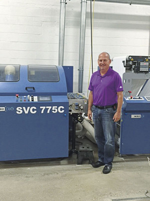 Allied Printing COO Tony Pelc stands next to the 30˝ SVC 775 C sheeter that is part of the SHP 800 high-pile stacking system from MBO America. The finishing equipment from MBO runs near-line to Allied&rsquo;s HP PageWide T300 inkjet web press.