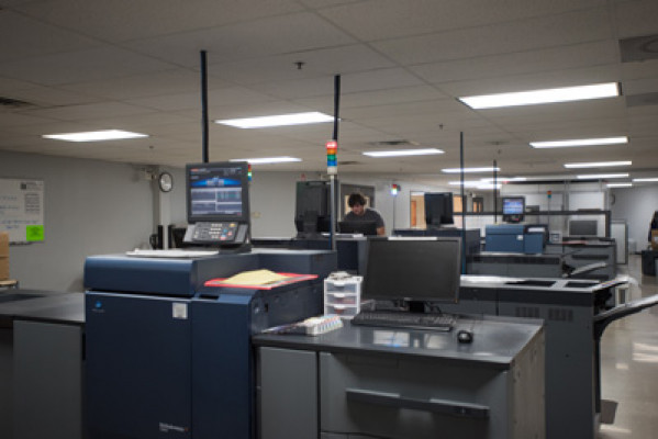 Operator Justin Czemierys stands inside the Hartland, Wis., plant&rsquo;s cut-sheet digital color room, which is equipped with nine high-speed Konica Minolta digital printers.