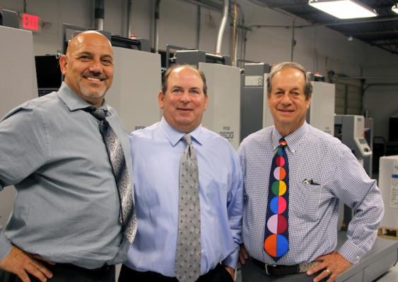 From the left, are partners Carl Piccari, Jim Rosenthal and John Rosenthal, standing in front of the new Ryobi 750G offset press.