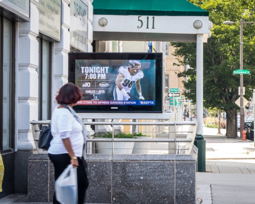 A passerby looks at the display promoting the Philadelphia Eagles on a digital urban panel.