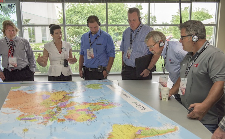 Attendees review a proof printed on the Acuity F high productivity UV flatbed printer.